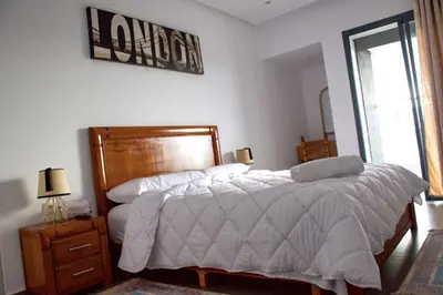 a bedroom with a bed and a sign on the wall at Modern Apt with sea view and access to the beach in El Harhoura