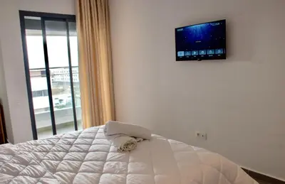 a bedroom with a bed with a flat screen tv on the wall at Modern Apt with sea view and access to the beach in El Harhoura