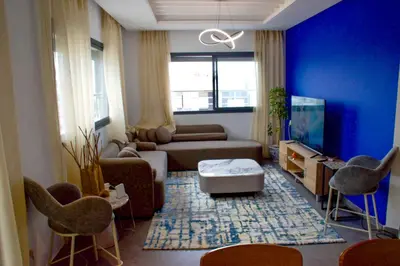 a living room with a couch and a tv at Modern Apt with sea view and access to the beach in El Harhoura