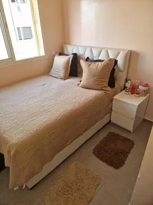 a bedroom with a large bed with a window at apartement avec piscine résidence sécurisée meublé confort jnan dalia Boznika in O Ben Slimane