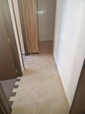 a hallway with a tiled floor and a wooden door at apartement avec piscine résidence sécurisée meublé confort jnan dalia Boznika in O Ben Slimane