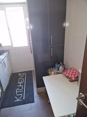 a small kitchen with a white counter and a sink at apartement avec piscine résidence sécurisée meublé confort jnan dalia Boznika in O Ben Slimane