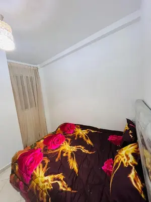 a bedroom with a bed with pink roses on it at Résidence safae in Casablanca