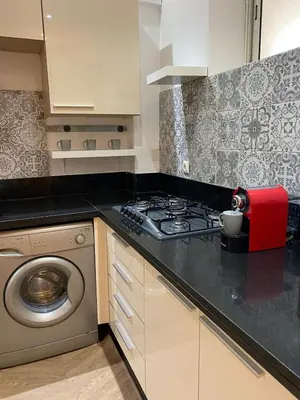 a kitchen with a stove and a washing machine at Joli Appartement 2 pièces in Rabat