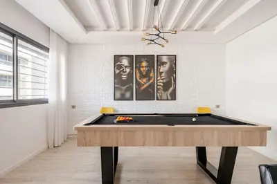 a billiard table in a room with pictures on the wall at La perle de Harhoura Piscine-Océan -Terrain Rabat in Temara