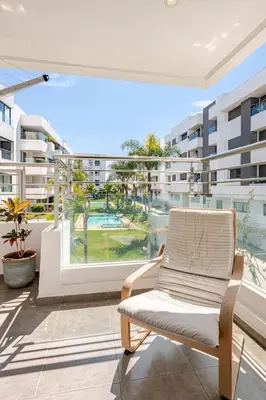 an apartment balcony with a chair and a view of a pool at La perle de Harhoura Piscine-Océan -Terrain Rabat in Temara