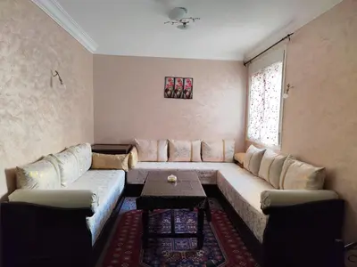 a living room with a couch and a table at Eco Gare centre 2 chambres in Bouznika