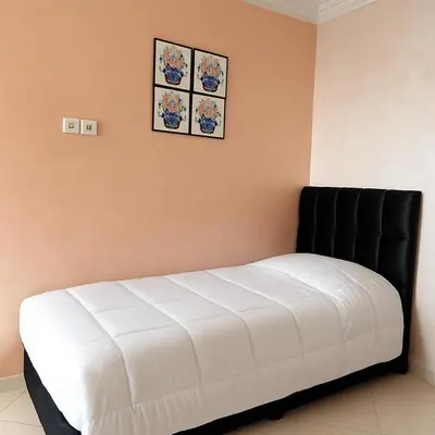 a white bed in a room with two pictures on the wall at Eco Gare centre 2 chambres in Bouznika
