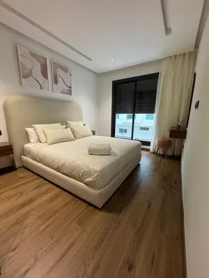 a bedroom with a large bed and a large window at Studio à louer in Casablanca