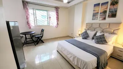a bedroom with a large bed and a table in it at Central Cosy studio steps to Shore in Rabat