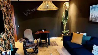 a living room with a blue couch and a table at Cozy private jacuzzi spa apartment in Casablanca
