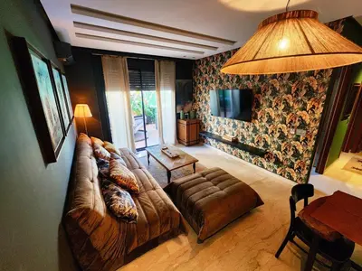 a living room with a leather couch and a television at Cozy private jacuzzi spa apartment in Casablanca