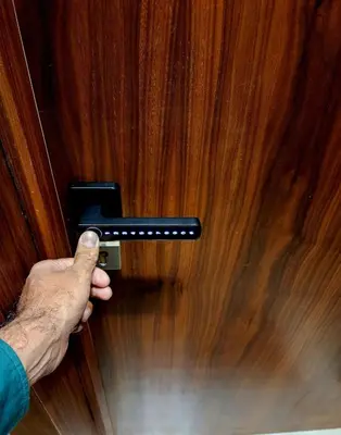 a person holding a door handle on a wooden door at Cozy private jacuzzi spa apartment in Casablanca