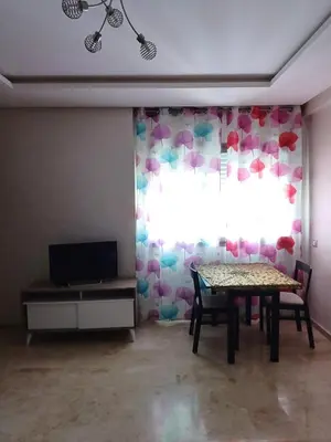 a dining room with a table and a window at Apartment kamal park G39 in Mohammedia