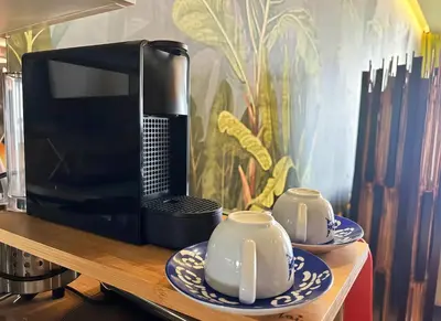 a microwave sitting on a wooden shelf with two cups at Maya Suites - Luxury Stay in Casablanca in Casablanca