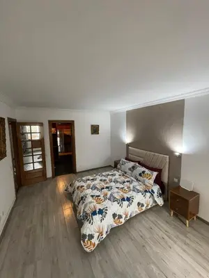 a bedroom with a large bed and a wooden floor at Bd les iris in Casablanca