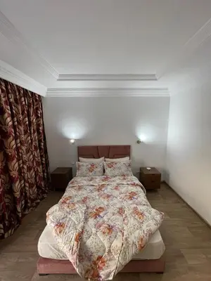 a bedroom with a large bed with a floral bedspread at Bd les iris in Casablanca