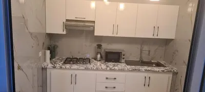a kitchen with white cabinets and a counter top at Rabat in Temara