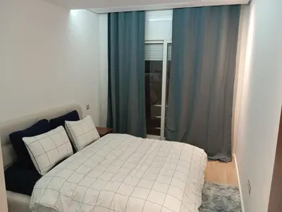 a bedroom with a white bed and a window at Ennour in Rabat
