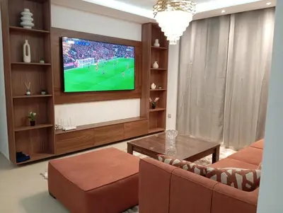 a living room with a tv and a couch and a table at Ennour in Rabat