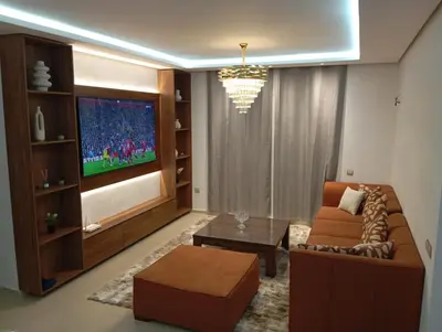 a living room with a couch and a tv at Ennour in Rabat