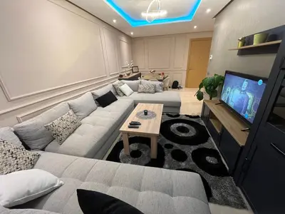 a living room with a couch and a tv at Appartement dans un cadre convivial in Rabat