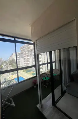 a room with a balcony with a view of a building at Appartement dans un cadre convivial in Rabat