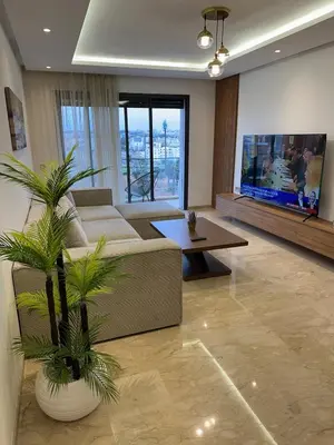 a living room with a couch and a tv at Cosy Appartement in Rabat