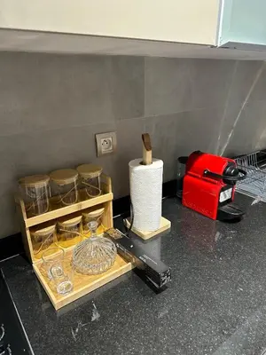a kitchen counter with glass dishes and a red toaster at Cosy Appartement in Rabat