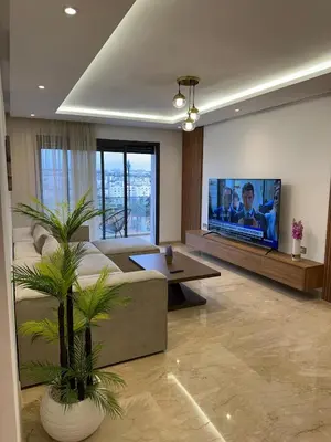 a living room with a couch and a flat screen tv at Cosy Appartement in Rabat