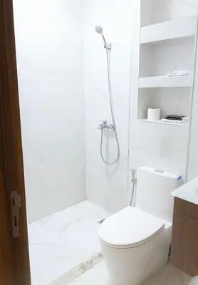 a white bathroom with a shower and a toilet at 2BR Beach Apt, Pool, Luxury place in Mansouria