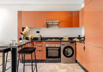 a kitchen with orange cabinets and a dishwasher at Studio Luxe avec vue Magnifique WiFi Haut Debit et Netflix Inclus in Casablanca