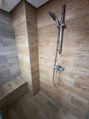 a shower in a bathroom with a wooden wall at VILLA Dar BOUAZZA, Vue sur mer, 200m de la plage in Dar Bouazza