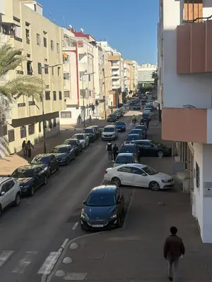 a city street with cars parked on the road at Apartment in Agdal, 3-min walk from Arribat Center in Rabat
