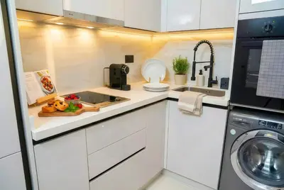 a white kitchen with a sink and a dishwasher at Maya Suites - Seaside Luxury Apartment in Casablanca