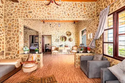 a large living room with a stone wall at La Tulipe de Zaer - Maison de Campagne vue Montagnes - Piscine Privée
