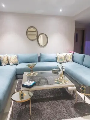 a living room with a blue couch and a table at Apartment with piscine in Mansouria