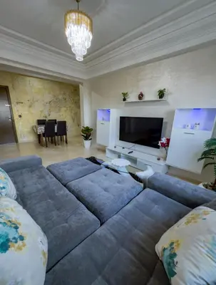 a living room with a couch and a flat screen tv at artisanat in Mohammedia