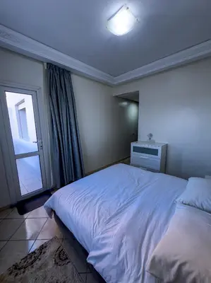 a bedroom with a large white bed and a window at artisanat in Mohammedia