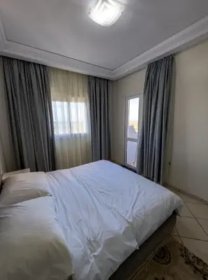 a bedroom with a white bed and a window at artisanat in Mohammedia