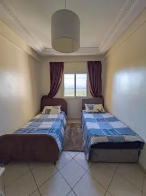 a bedroom with two beds and a window at artisanat in Mohammedia