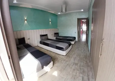 two beds in a room with green walls at well-equipped apartment in Mansouria