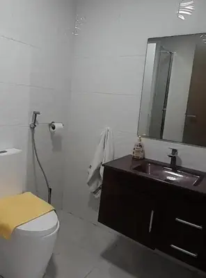 a bathroom with a sink and a toilet and a mirror at well-equipped apartment in Mansouria