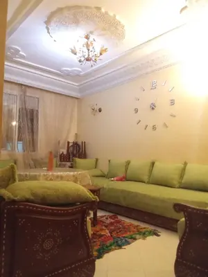 a living room with a couch and a clock on the wall at Younes Home in Casablanca