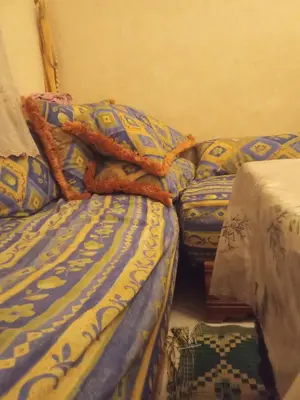 a bedroom with a bed with a blanket and pillows at Younes Home in Casablanca