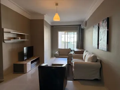 a living room with a couch and a tv at Cozy Downtown Apartment - Casa Port TGV in Casablanca
