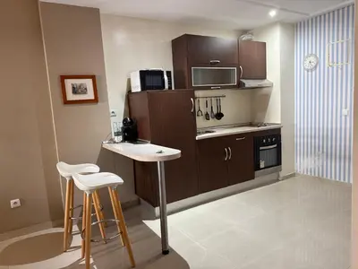 a kitchen with a table and two bar stools at Cozy Downtown Apartment - Casa Port TGV in Casablanca