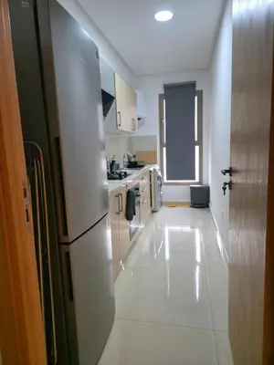 a kitchen with white cabinets and a refrigerator at super studio in Aïn Harrouda