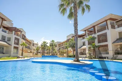 a swimming pool with palm trees and buildings at Seaside Luxury 3BR With Pool & Private Beach Access in Bouznika