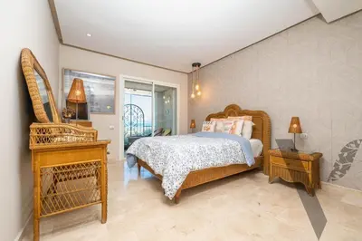 a bedroom with a bed and a table and a window at Seaside Luxury 3BR With Pool & Private Beach Access in Bouznika